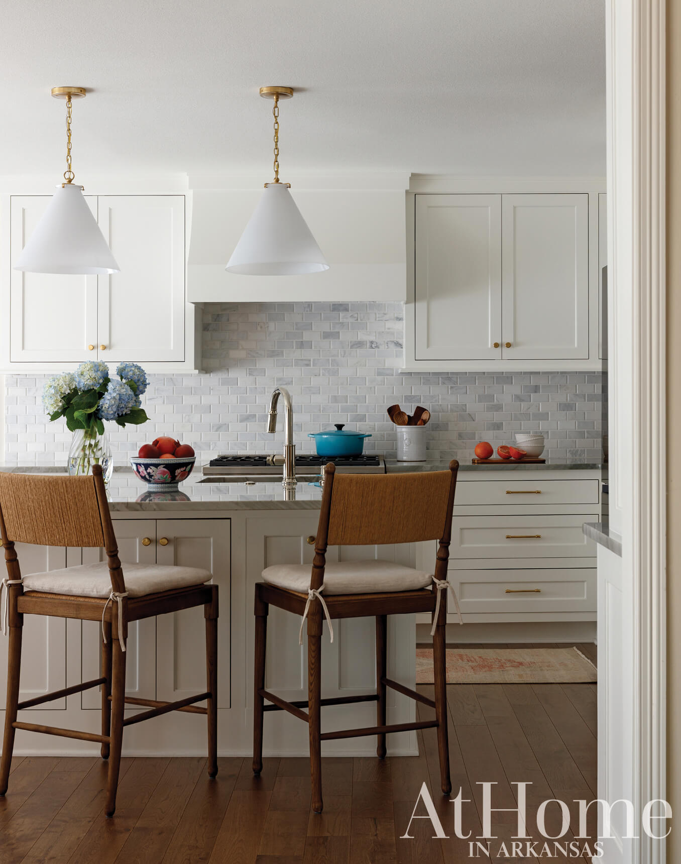 White kitchen with marble tile backsplash and wood cabinetry.