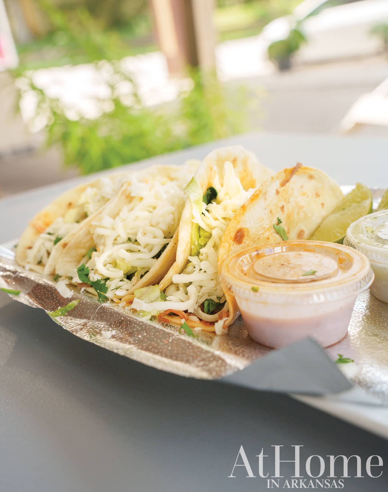 Vietnamese tacos on a silver tray with dipping sauce.