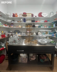 Spacious pantry with shelves filled with dishes and supplies.