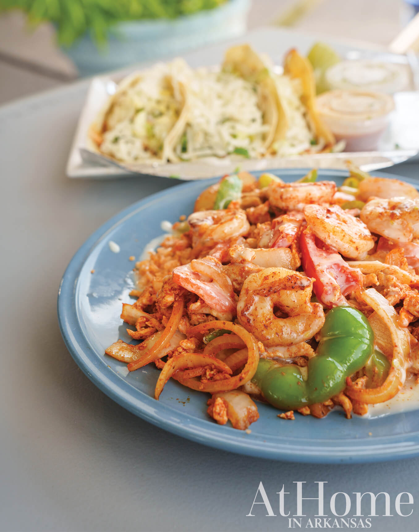 Shrimp Pad Thai with vegetables and sauce on a blue plate.
