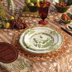 Table setting with plates, grapes, and a patterned tablecloth.