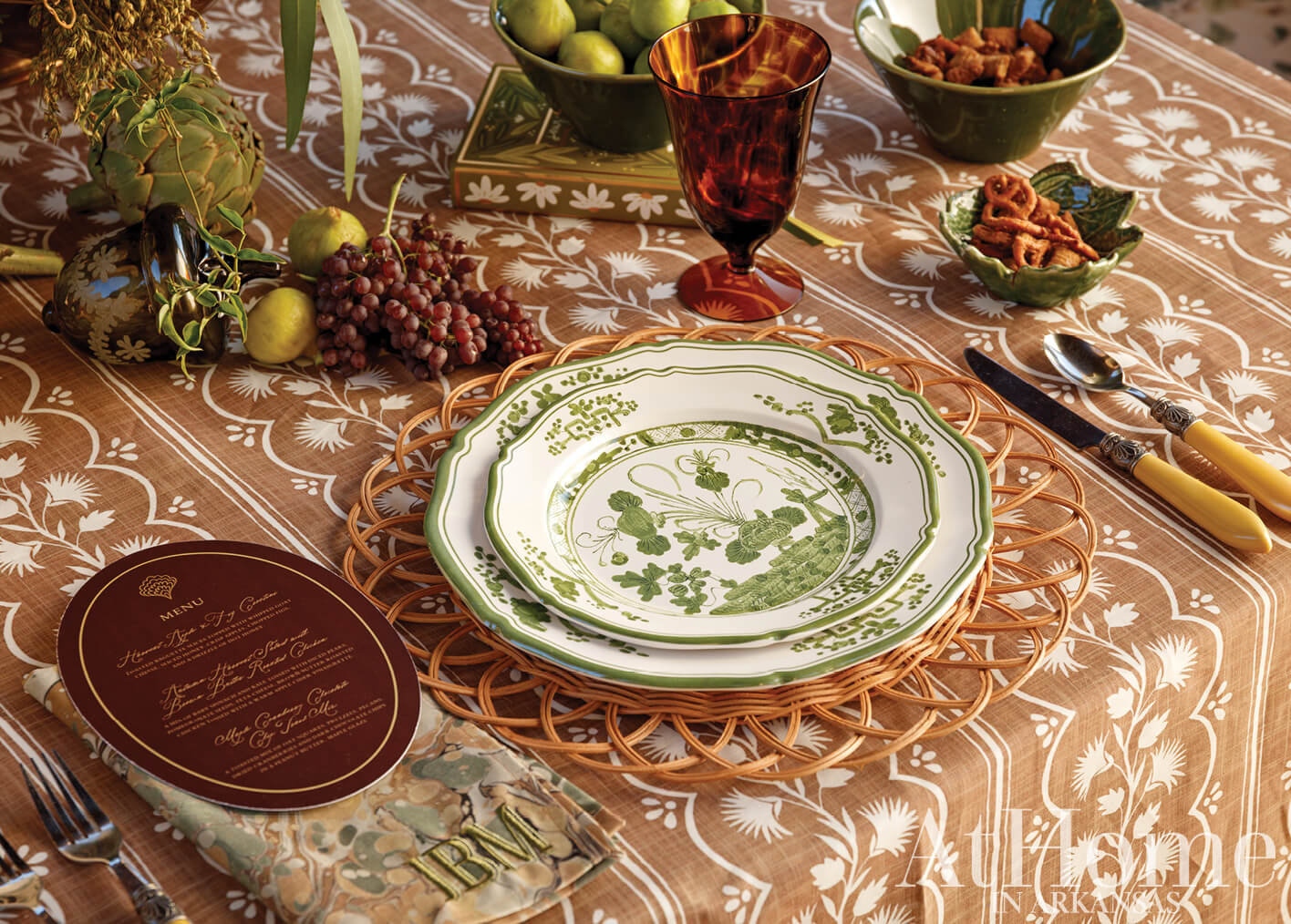 Table setting with plates, grapes, and a patterned tablecloth.