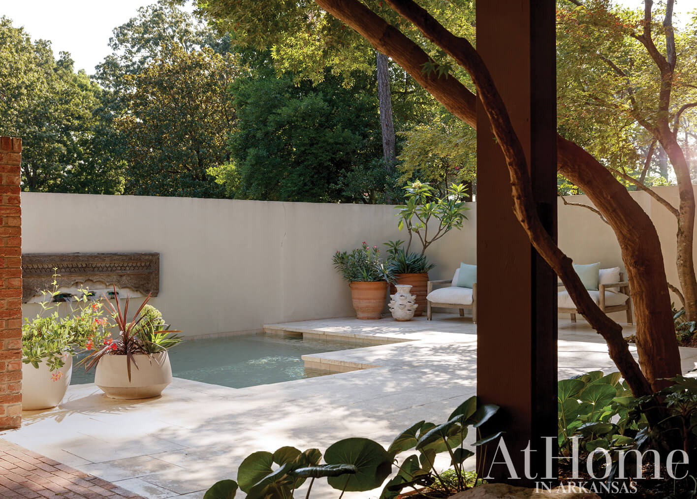 Brick wall with pool, planter, and outdoor seating in Arkansas.