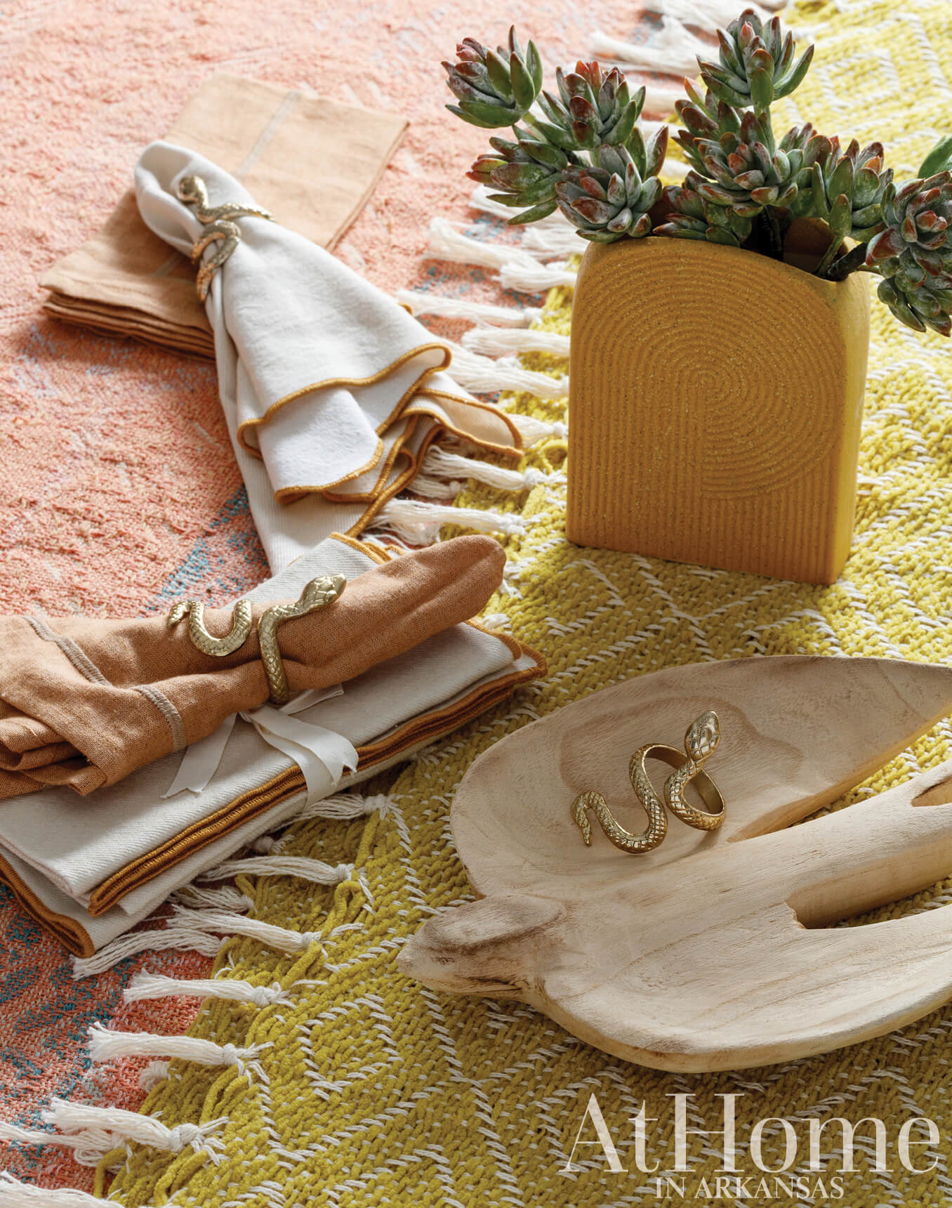Succulents, napkins, and tableware on a patterned rug.