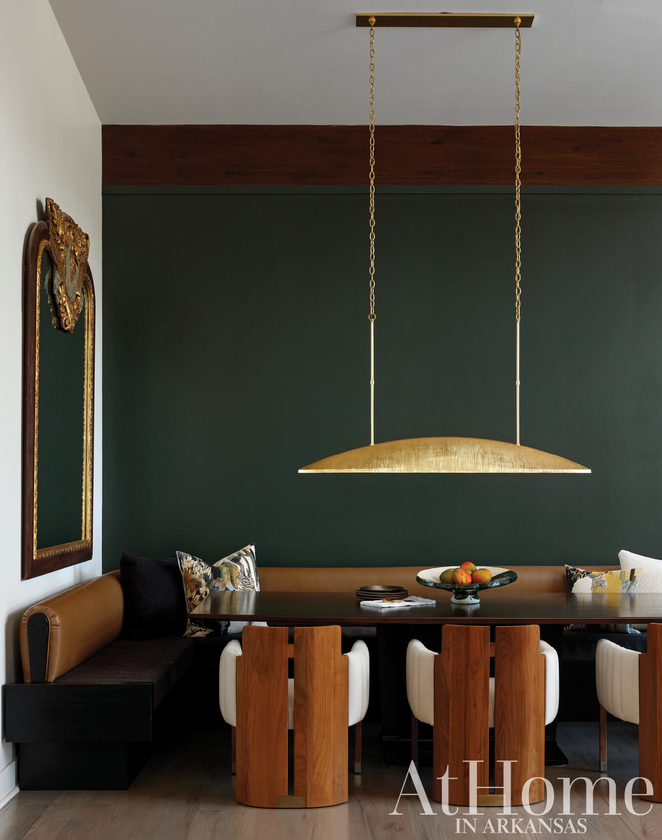 Gold pendant light hangs above a wooden dining table.