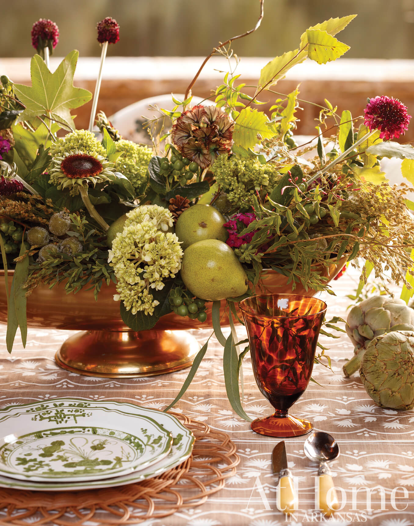 Floral centerpiece on a patterned table with tableware.