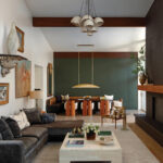 Living room with dark green wall, wooden table, and gray sofa.
