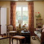Living room with patterned curtains, a chandelier, and furniture.