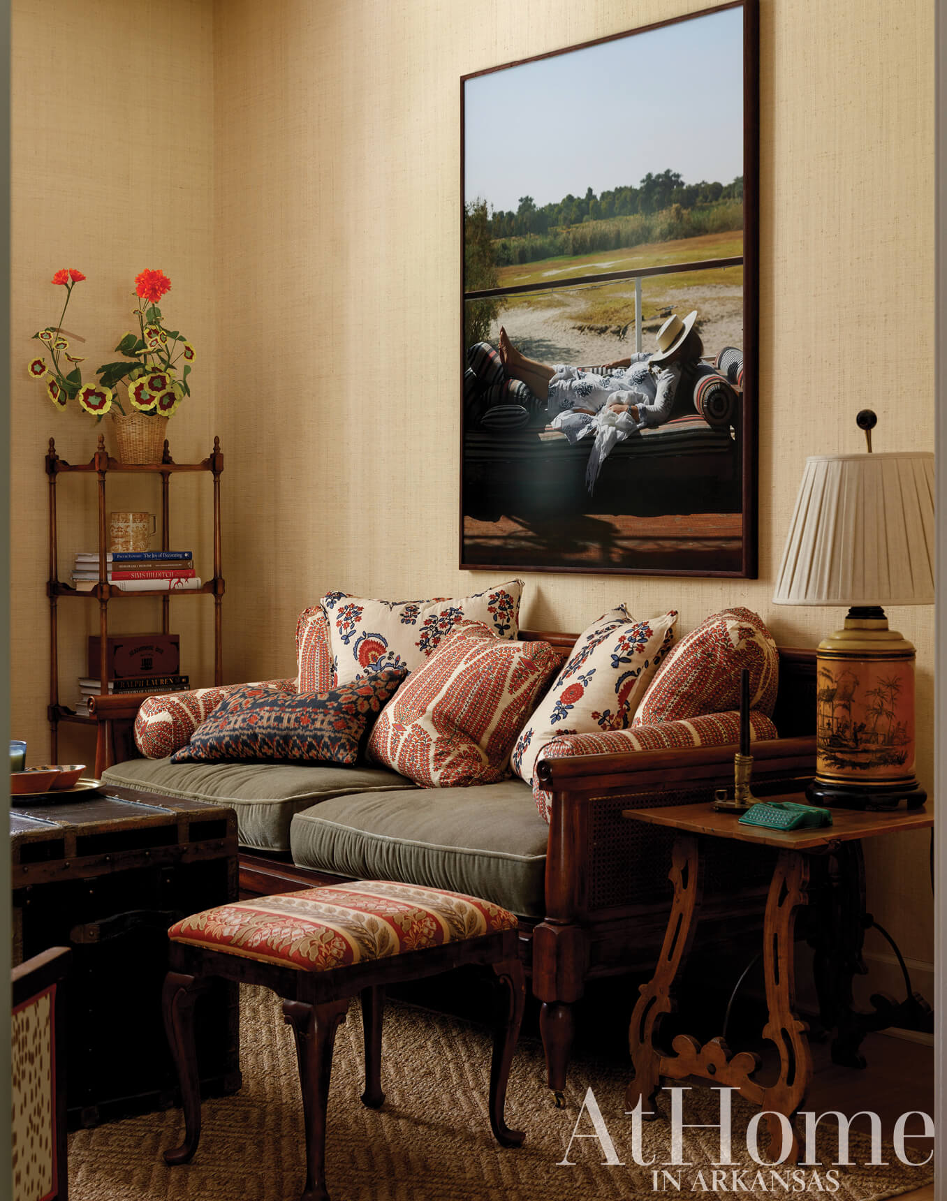 Living room with framed landscape painting, patterned sofa, and side table.