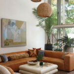 Tan leather sofa with layered pillows and a coffee table.
