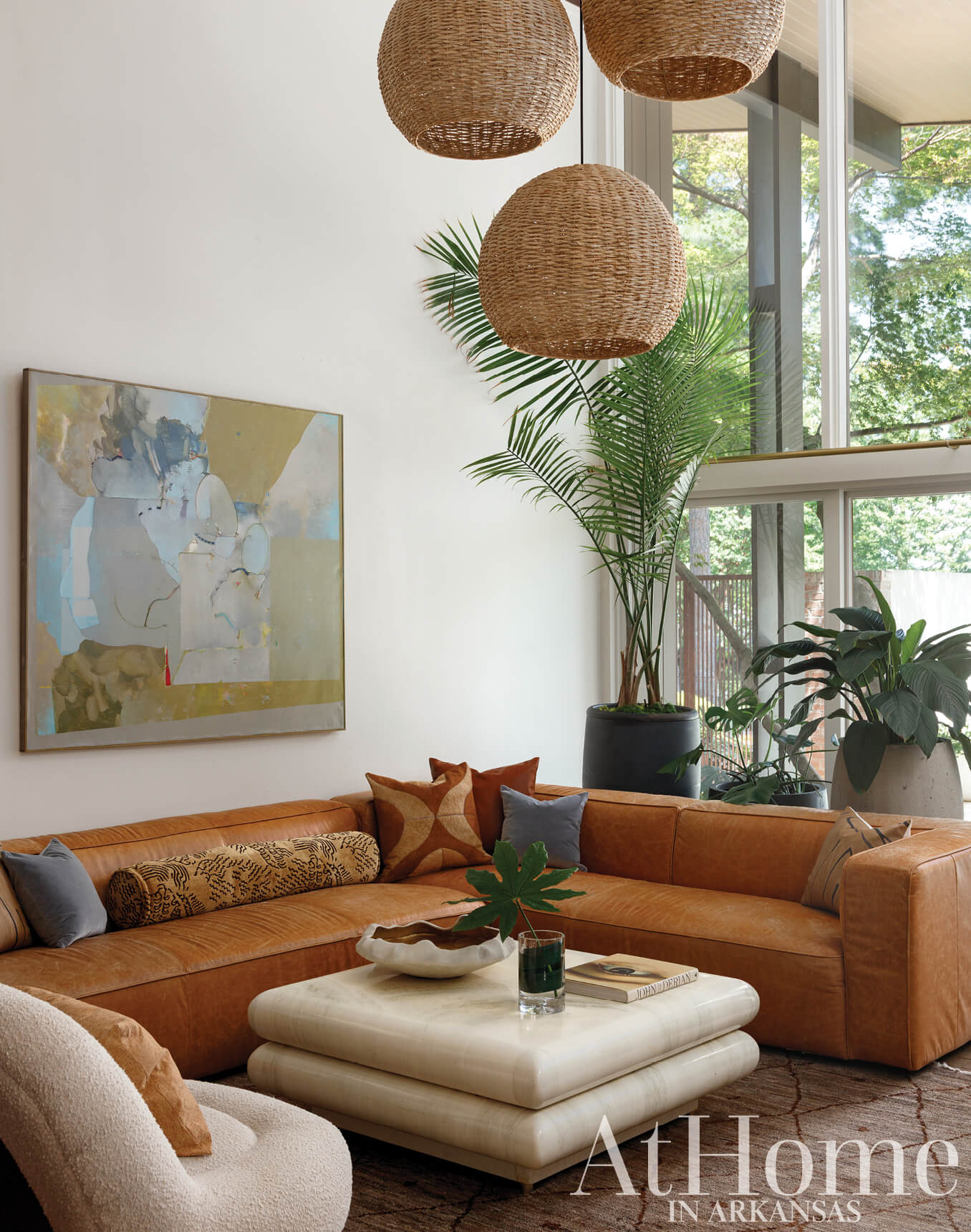 Tan leather sofa with layered pillows and a coffee table.