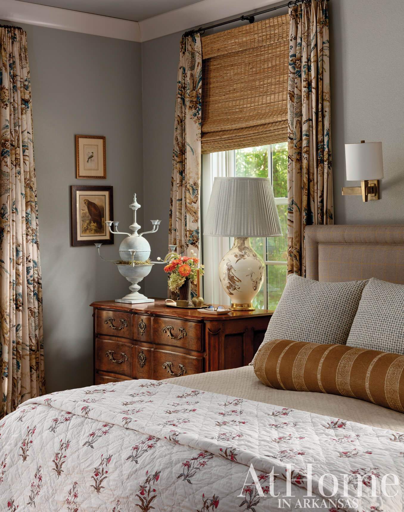 Bedroom corner with a large bed, curtains, and a dresser.