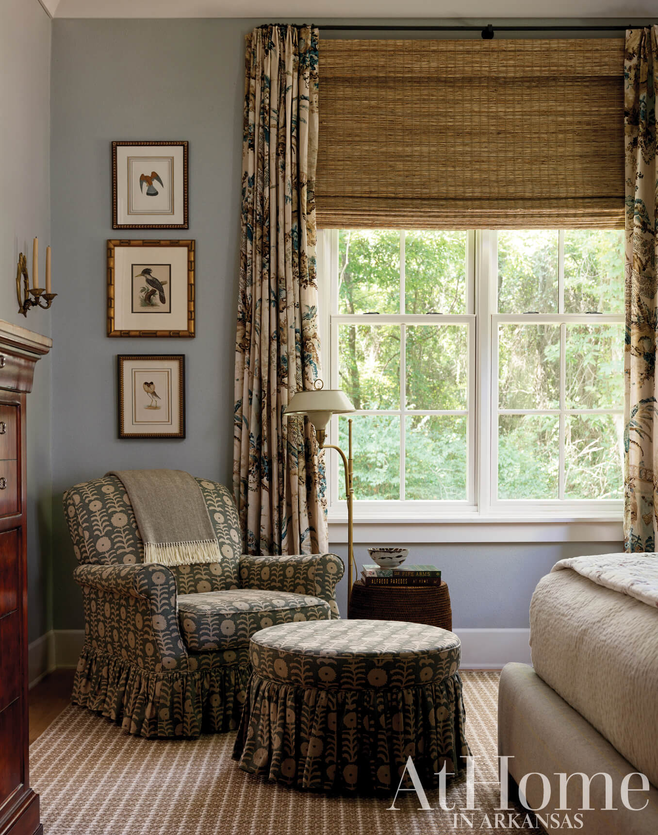 Blue and patterned armchair in a bedroom with a large window and curtains.